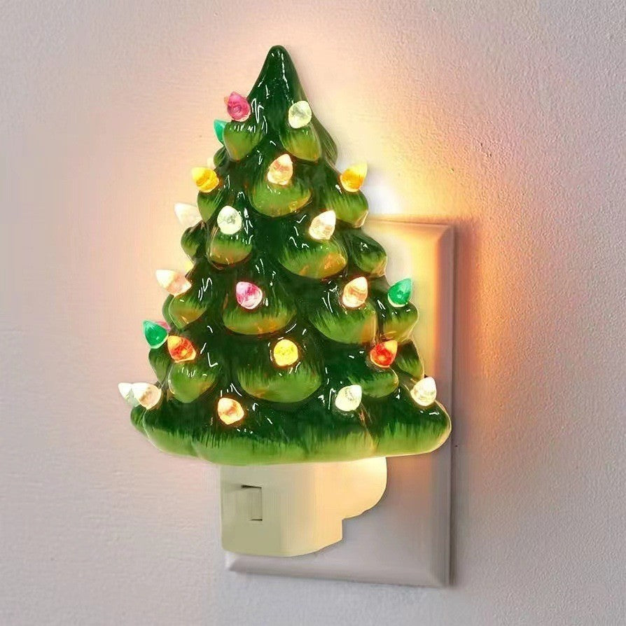 Decorative night light shaped like a Christmas tree with lights on a plain wall.