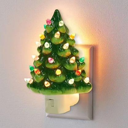 Decorative night light shaped like a Christmas tree with lights on a plain wall.
