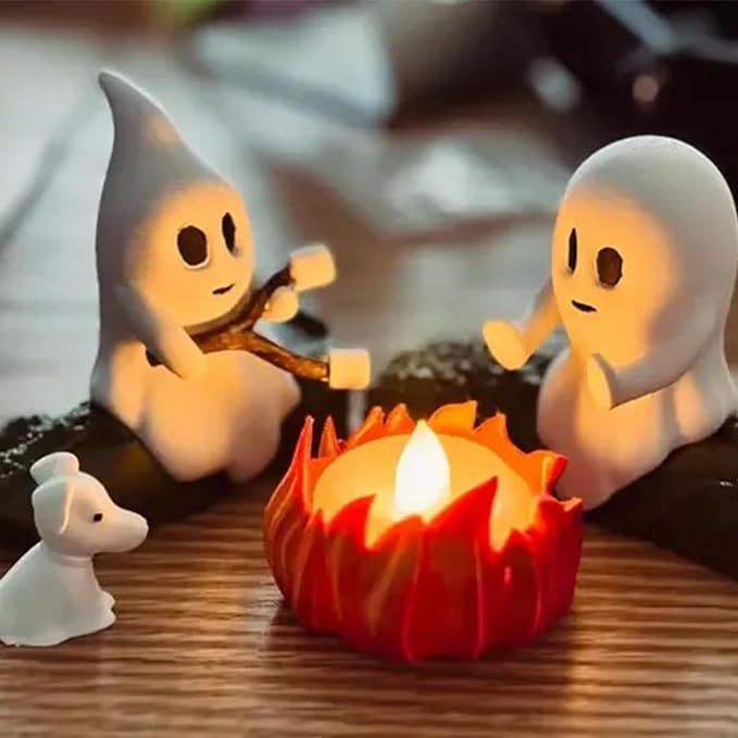 Ghost Bonfire Party Night Light by a lit candle on a wooden surface