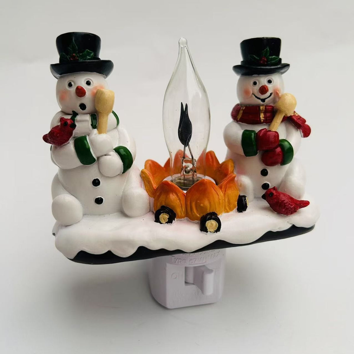 Decorative night light with two snowmen and a fire, featuring a brand logo.